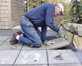 Image of a man laying flagstone paving